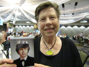 Betty Hagberg of Moline holds up her U.S. Navy photo from the 1960s during a pre-flight dinner Thursday, May 19, at the Waterfront Convention Center, Bettendorf. She among eight women veterans who will travel on next week’s Honor Flight of the Quad Cities