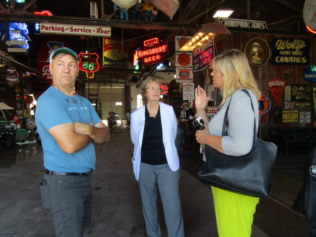 Kathy La Plante, center, Main Street America’s senior program officer and director of coordinating program services, visits with Robbie Wolfe, a star of the TV series “American Pickers” at his shop in Davenport, and Molly Otting Carlson, Hilltop Campus Village executive director, during a tour of Davenport’s Hilltop on Thursday, Aug. 18.