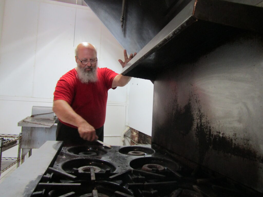 Todd Herzog, one of the owners of the Life Breads Gluten-Free Bakery at 1509 N. Harrison St., Davenport, cleans a stove in the storefront
