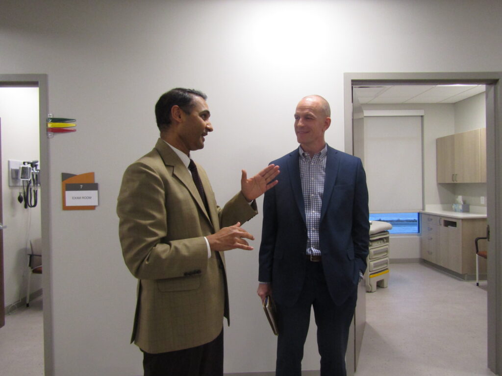 Dr. D.V. Singh, left, owner of Midwest Medical Clinic, talks with A.J. Loss, president and CEO of Bush Construction, during an open house Friday, Dec. 16, of the new medical care clinic in Davenport.