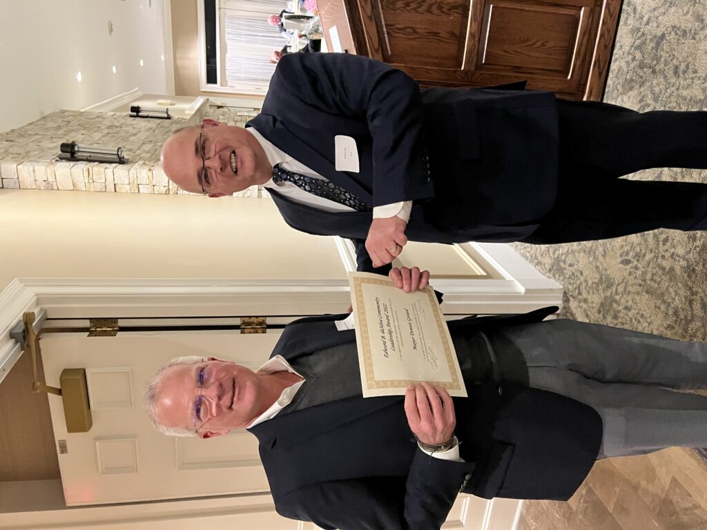 Rob Cain, right, the president of the LeClaire Chamber of Commerce, presents LeClaire Mayor Dennis Gerard with the Edward B. deSilva Award on Saturday, Jan. 28.