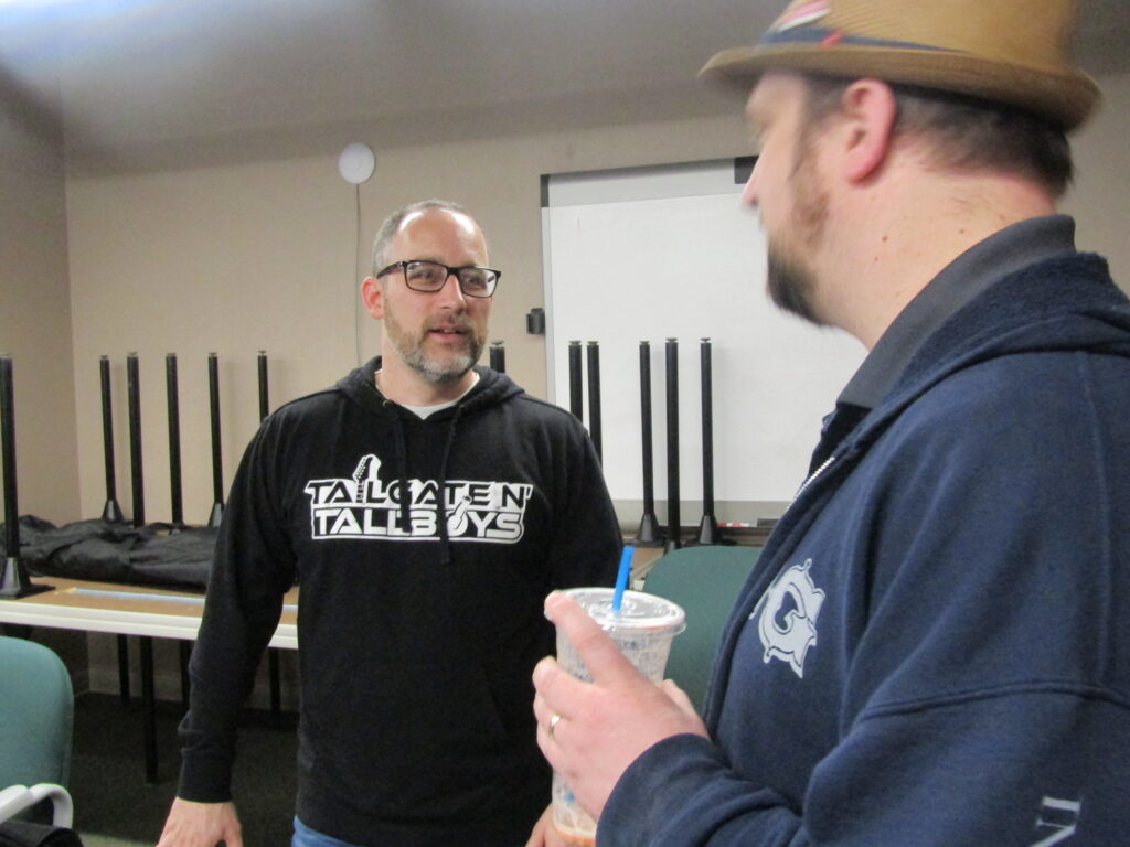 Clinton Mayor Scott Maddasion, left, discusses the Tailgates N’ Tallboys Music Festival during a meeting Friday, March 31, at the Grow Clinton office.