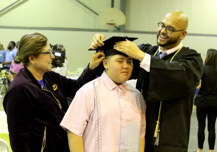 Jorge putting cap on brother