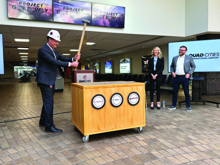 Benjamin Leischner, executive director of the Quad Cities International Airport, slams a sledgehammer into a mock brick floor in late April kicking off Project Gateway’s Phase Two construction. CREDIT JENNIFER DEWITT