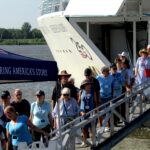 Passengers disembark from the American Serenade river cruise ship on the Muscatine riverfront on Monday morning, June 29. Around 155 people from the ship spent the morning in Muscatine.