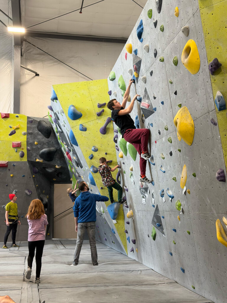 Rockhouse Nick Perreault (in blue) stands on the floor as his children tackle a climbing wall. He is pursuing a new startup business Rockhouse Quad Cities, which would be the first climbing gym in the QC region. CREDIT NICK PERREAULT